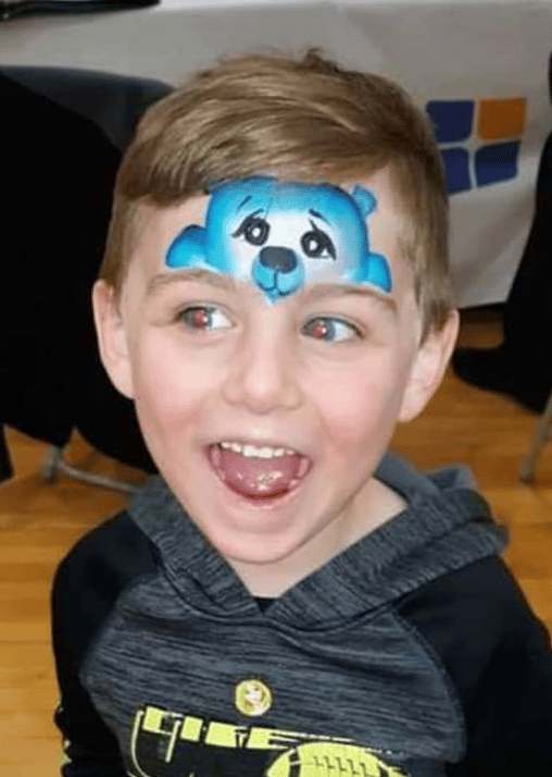 A child with a detailed bear face-painting design